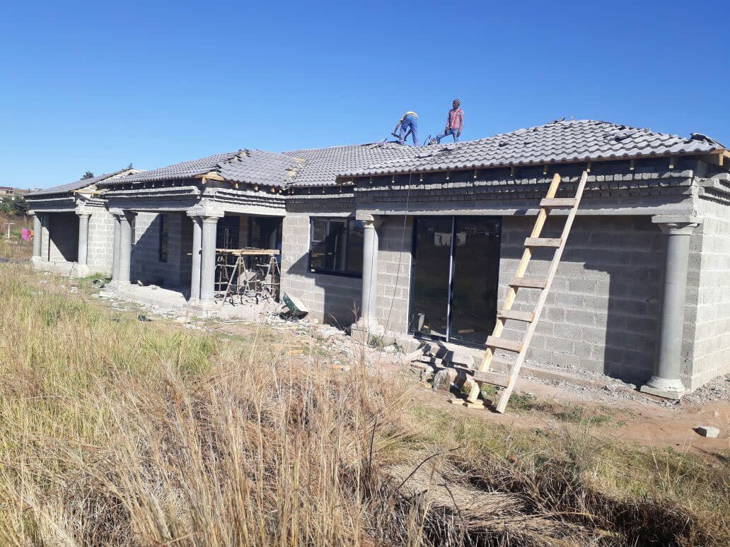 House with builders working on a roof